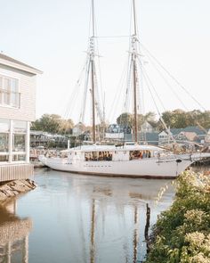 a sailboat is docked in the water next to a dock with houses on it