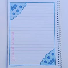 an open notebook with blue writing on the page and clouds in the sky above it