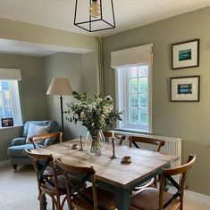 a dining room table with chairs and flowers in a vase on the top of it