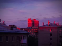 red lights shine on the tops of buildings in an urban area at sunset or dawn