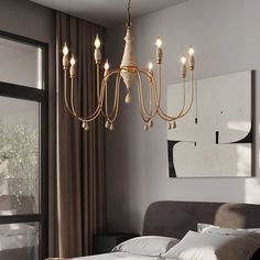 a chandelier hanging over a bed in a bedroom next to a large window