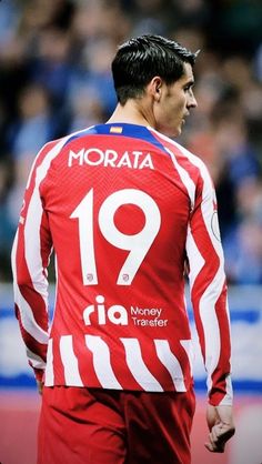 the soccer player is wearing red and white stripes on his uniform, while he looks to his left