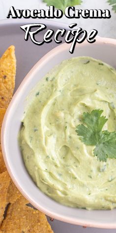 a bowl filled with guacamole next to tortilla chips and cilantro