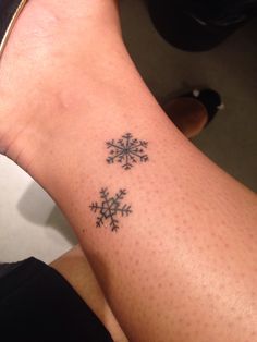 a person with a snowflake tattoo on their arm and foot is looking at the camera