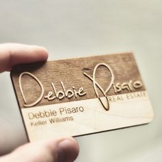 a person holding up a business card with the name debbbie pisaro on it