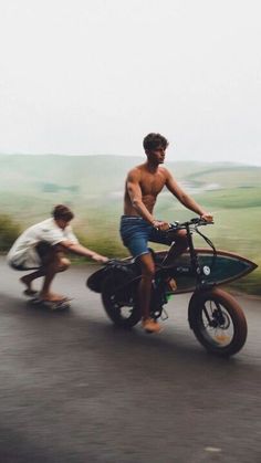 two young men riding small motorcycles on the road