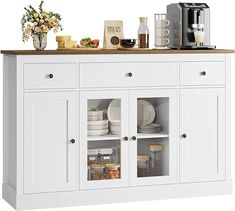 a white cabinet with glass doors and shelves filled with plates, bowls, cups and other items