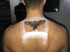 the back of a man's shoulder with patches on it and an eagle painted on his chest