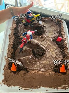 a birthday cake decorated with dirtbikes and dirt bikes on top of chocolate frosting