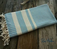 a blue and white striped towel laying on top of a wooden floor next to a bone