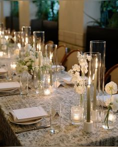 a long table is set with candles and flowers for a formal dinner or wedding reception