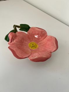 a pink flower sitting on top of a white table