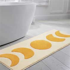 a white bath tub sitting next to a yellow rug