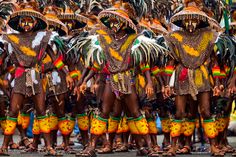 a group of people standing next to each other wearing costumes and headdresses