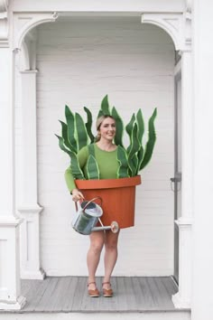 a woman holding a potted plant and watering can