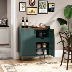 a green cabinet in a kitchen next to a dining room table with chairs and pictures on the wall