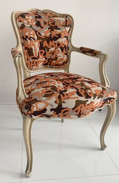 a chair with an orange and black camouflage pattern on it's back, against a white wall