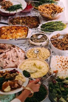 a table topped with lots of different types of food and dishes filled with meats