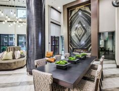 a large dining room table with chairs and plates on it in front of an art work