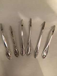 five silver spoons are lined up next to each other