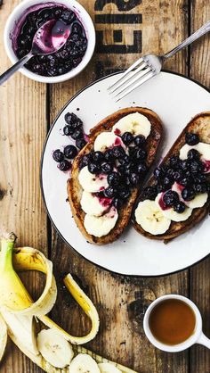 two pieces of toast with bananas and blueberries on it