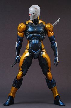 the action figure is posed in front of a gray background with black and yellow accents