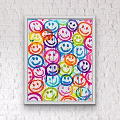 a white brick wall with a multicolored smiley face painting on it's side