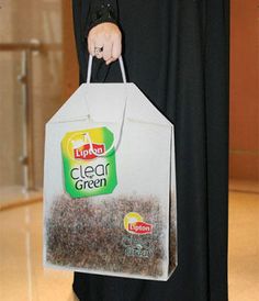 a woman holding a bag full of clear green tea bags in her hand