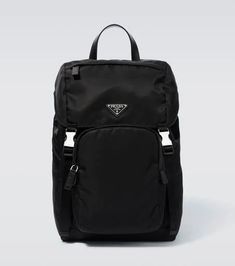 This Prada backpack is the result of an evolved ‘80s archival design. Made from eco-friendly Re-Nylon, this accessory features Saffiano leather trims with a crosshatch and waxed finish, and an iconic triangle logo plaque..Top handle, Adjustable shoulder straps.Color of fastening: silver.Material: fabric.Internal details: internal slot pocket, internal zipped pocket, fabric lining.Designer color name: Nero.Made in Italy.Zipped front pocket, Side pockets.Closure: buckle fastening , drawstring top. Nylon Standard Backpack With Logo Patch, Travel Backpack With Logo Hardware, Designer Nylon School Bags, Nylon Backpack With Logo For Everyday Use, Modern Nylon Bags With Logo Hardware, Modern Backpack With Logo Patch, Everyday Nylon Backpack With Logo, Travel Nylon Bag With Logo, Luxury Nylon Bags With Logo Patch