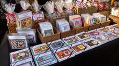 many cards are on display in baskets at a market table with other items for sale