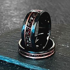 two wedding bands with blue and black diamonds