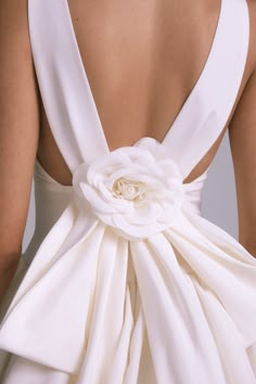 the back of a woman's dress with a flower on it