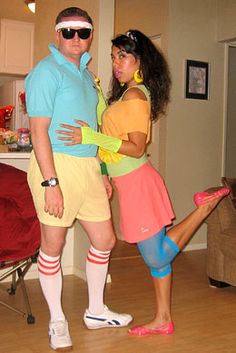 a man and woman dressed in costumes standing next to each other on a hard wood floor