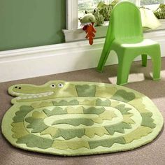 a child's room with a green chair, rug and toy snake on the floor