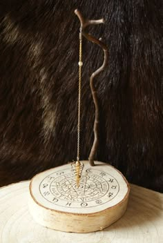 a wooden stand with an arrow on it and a chain hanging from the end, in front of a brown fur background