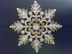 a gold and white snowflake on a black background