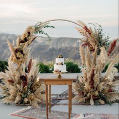 a table with two cakes on it and some flowers