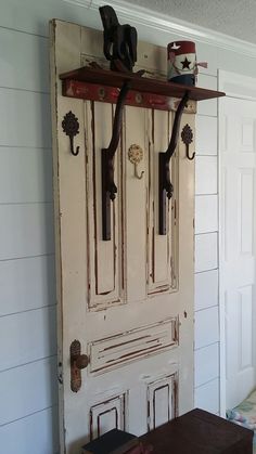 an old door with two hooks on it