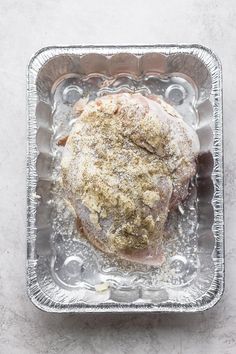 a piece of meat sitting on top of a metal pan covered in powdered sugar