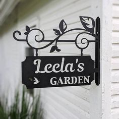 a sign that says leeda's garden hanging from the side of a house