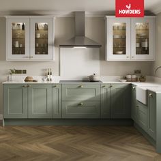 an image of a kitchen setting with green cabinets and wood flooring on the walls