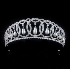 Grand Duchess Vladimir Royal Replica Tiara Crown This regal tiara is a replica of the tiara created for Grand Duchess Maria Pavlovna of Russia as pictured on Queen Elizabeth. This fabulous 2" tall silver platinum plated headpiece features a unique design of interlocking circles accented with hanging pearls. The AAA quality cz crystals and luminous shell pearls will provide sparkle from every angle! This crown will ensure head-turning elegance on your big day. Color: Silver. Style: hp223QE. Size: Diamond Tiaras Royal, Queen Elizabeth Wedding Tiara, Vladimir Tiara, Grand Duchess Vladimir, Beaded Tiara, Diamond Craft, Maria Pavlovna, Prom Tiaras, Pastel White