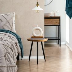 a bed room with a neatly made bed and a night stand next to the bed