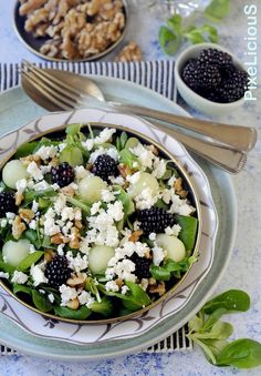 a salad with spinach, blackberries and feta cheese