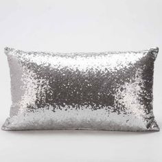 the silver sequin pillow is shown on a white background, it's shiny and has