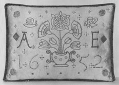 an old embroidered pillow with flowers and birds on the front, in black and white