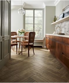 an image of a kitchen with wood floors and tile on the floor, in front of a window