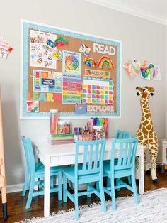 a child's room with a giraffe toy next to a table and chairs