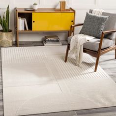 a living room with a yellow cabinet and white rugs on the floor in front of it