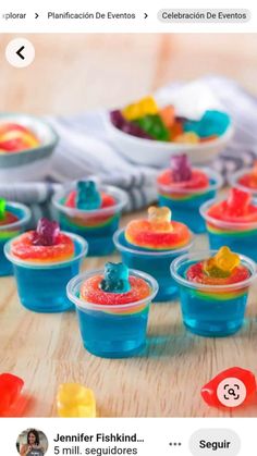 small plastic cups filled with gummy bears on top of a wooden table